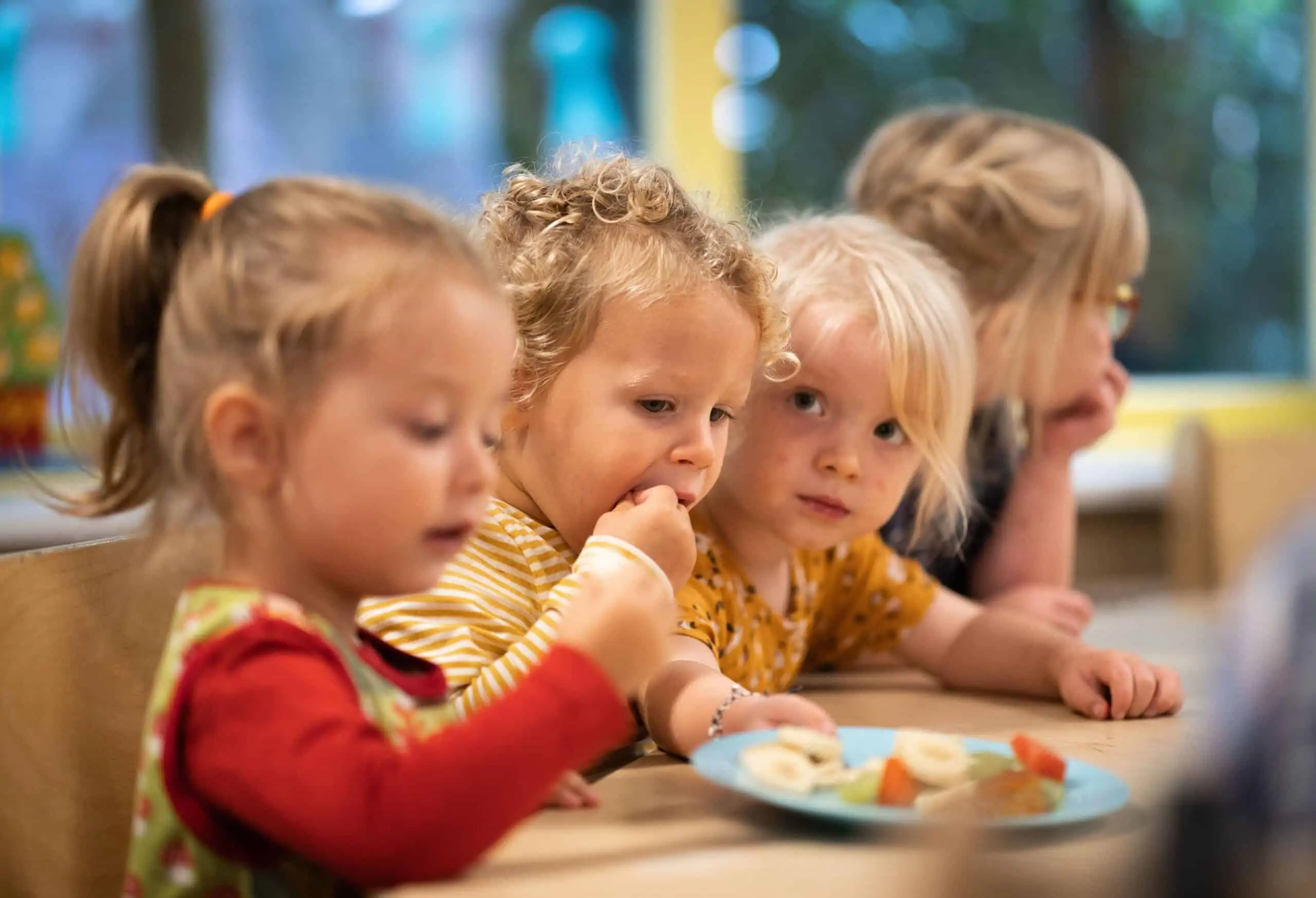 Peuters eten samen fruit aan tafel bij Poespas