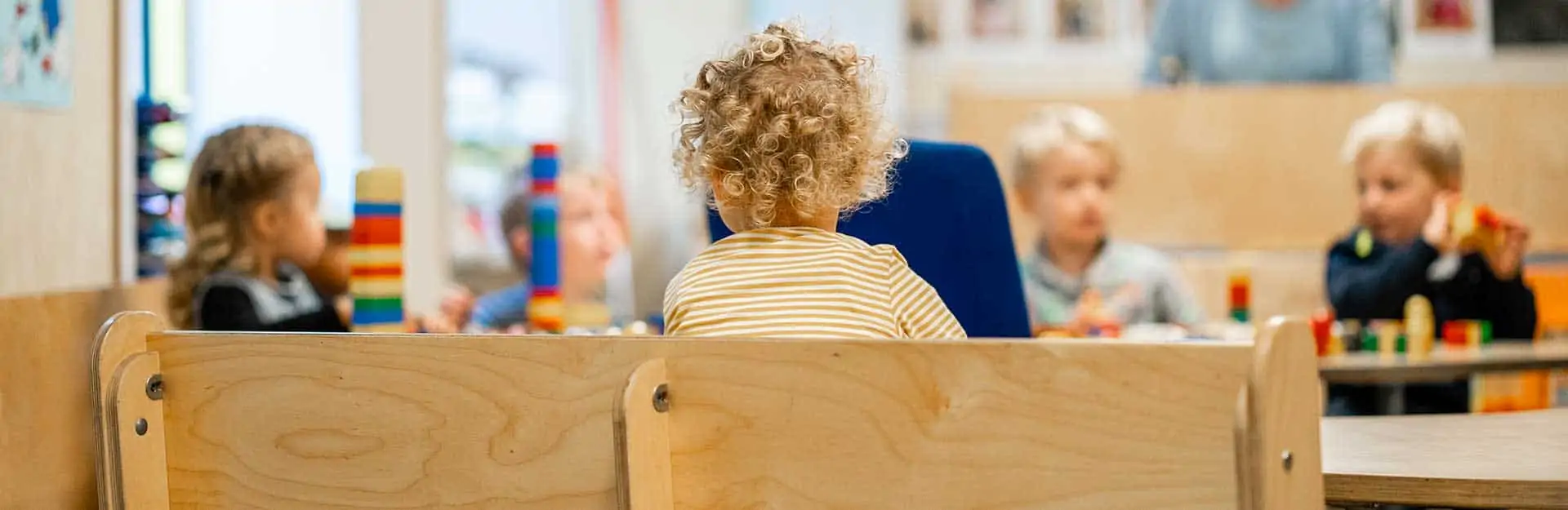Kinderen spelen met blokken aan tafel bij kinderdagverblijf Poespas