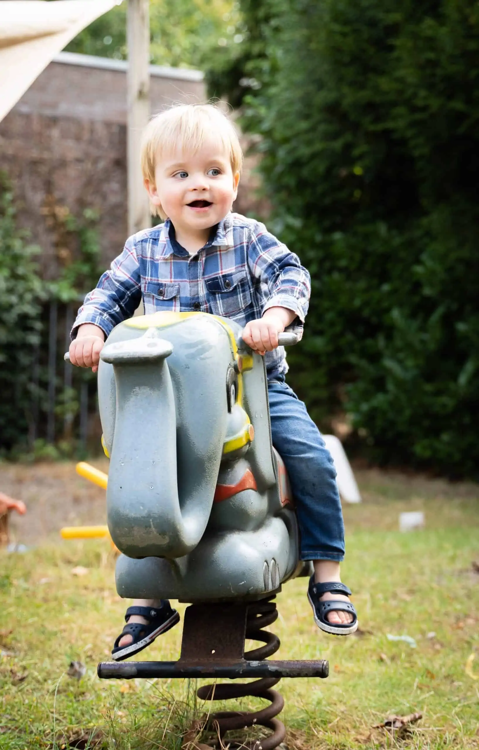Jongen op een veerelement in de tuin van Poespas