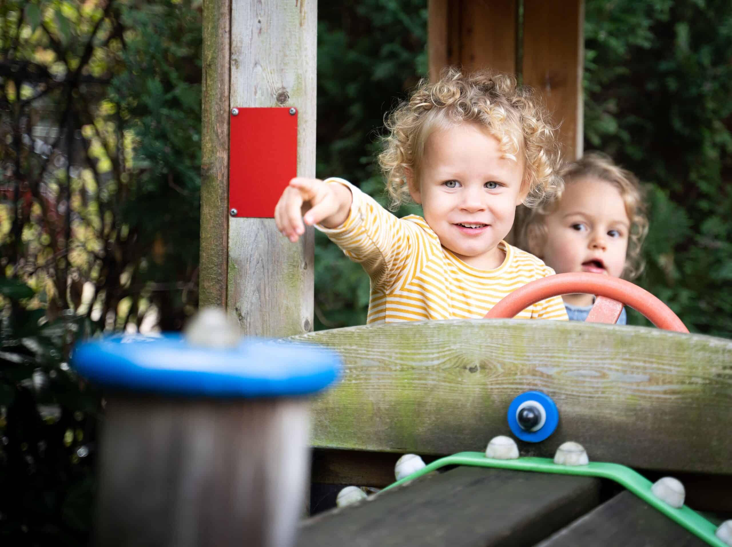 Twee peuters spelen in de speeltuin van Poespas