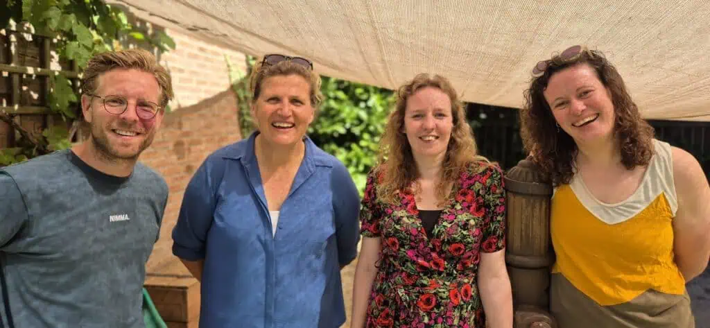 Familie en personeel bij kinderdagverblijf Poespas in een gezellige tuinsetting.
